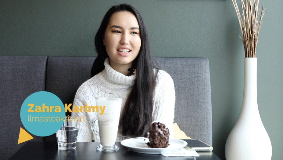 A dark-haired woman is sitting in a café. Her expression is concentrated. The name Zahra Karimy appears in the text of the photo.